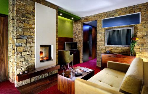 a living room with a couch and a fireplace at Wellness Hotel Chopok in Demanovska Dolina