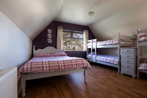 a attic bedroom with two bunk beds and a window at Lakeland House in Cong