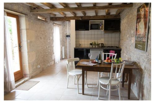 cocina y comedor con mesa y sillas en Domaine de la Grange aux Dîmes, en Feux