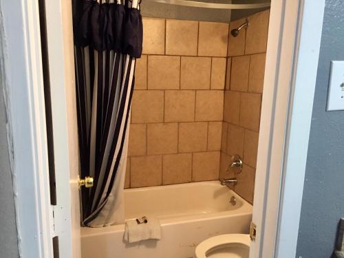 a bathroom with a bath tub and a toilet at Oasis Motel in Arlington