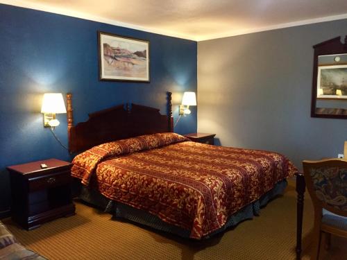 a hotel room with a bed and two lamps at Oasis Motel in Arlington