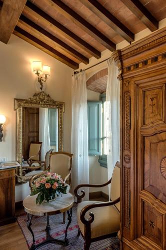 a living room with a table and chairs and a mirror at Hotel Mulino di Firenze - WorldHotels Crafted in Florence