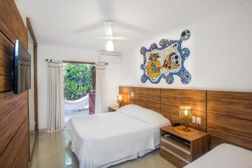 a bedroom with two beds and a clock on the wall at Pousada Ogum Marinho in Praia do Forte
