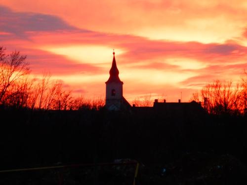 a silhouette of a building with a sunset in the background at Liszkay Borkúria in Monoszló