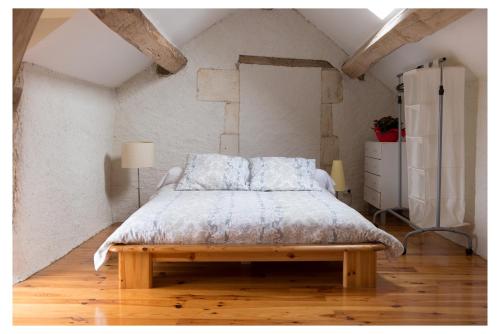 1 dormitorio con 1 cama y suelo de madera en Domaine de la Grange aux Dîmes, en Feux