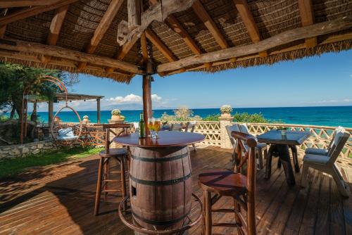 un patio con due tavoli, sedie e l'oceano di Porta del mar Beach Resort a Méson Yerakaríon
