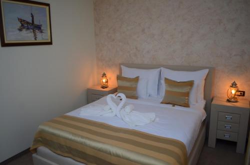 a bedroom with a bed with a swan on it at Hotel Helada in Tivat