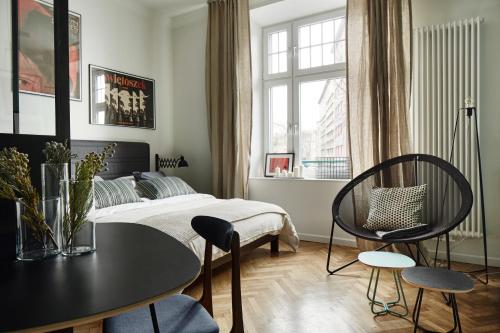 een slaapkamer met een bed en een tafel en stoelen bij FOUR STORIES APARTMENTS - Krasinskiego in Krakau