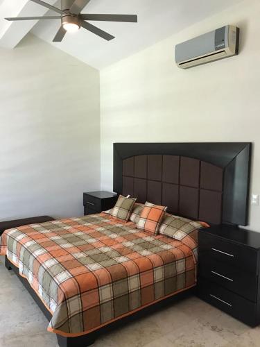 a bedroom with a bed and a ceiling fan at Casa Bonita cerca de playa in Bucerías