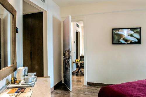 a room with a bed and a hallway with a table at Civitel Akali Hotel in Chania Town