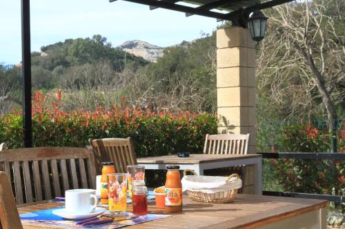 un tavolo di legno con delle bevande sopra in un patio di Chambres d'hôtes Multari a Patrimonio