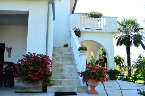 a white house with flowers on the stairs at Apartments Stivic in Pinezici