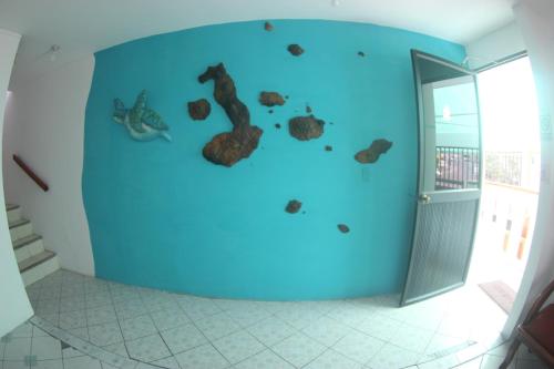 a room with a blue wall with animals painted on it at The Island Home in Puerto Ayora