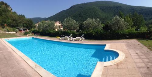 einen Pool mit zwei Stühlen und einem Berg in der Unterkunft Locanda Salimbeni in San Severino Marche