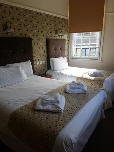 a hotel room with two beds with towels on them at The Fazeley Inn in Fazeley