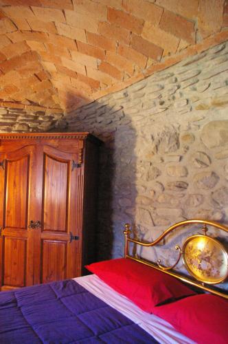 a bedroom with a bed with a stone wall at Locanda di Campagna in Mulazzo