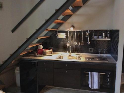 a kitchen with a sink in a attic at Las Glicinas Boutique Apartments in Colonia del Sacramento