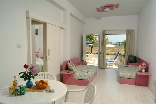 a living room with a table and chairs and a patio at Sunbay Apartments in Pyla