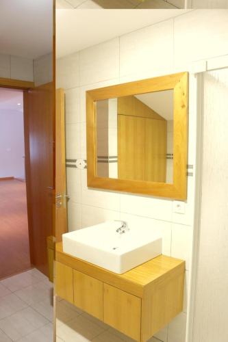 a bathroom with a white sink and a mirror at Cantinho Das Praias in Vila Franca do Campo