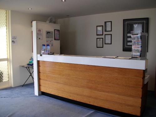 a kitchen with a wooden floor and wooden cabinets at Otway Gate Motel in Colac