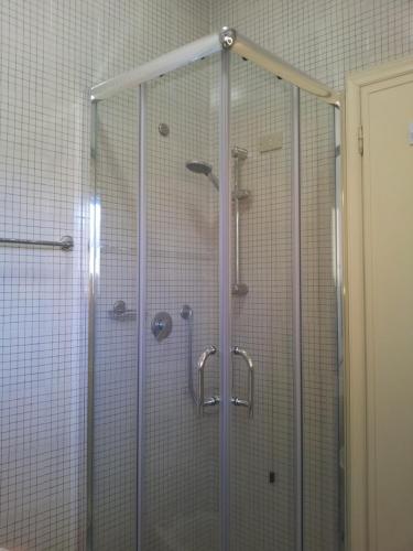 una doccia con porta in vetro in bagno di Appartamento City Garden a Viareggio