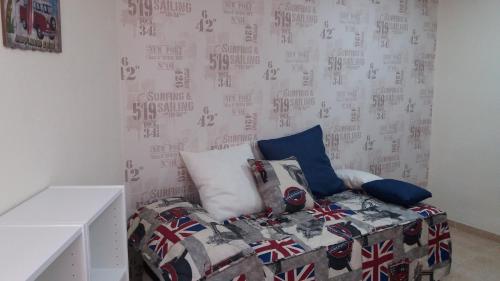 a bed in a room with a wall with british flag at APARTMENTSUITESPAIN Beach Economy in Valencia