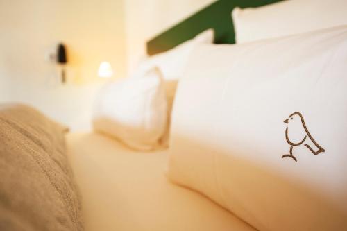 a bed with a pillow with a bird on it at Romantik Hotel Meisenheimer Hof in Meisenheim