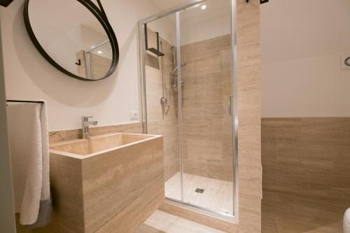 een badkamer met een douche met wastafel en spiegel bij Il Fuoco di Archimede - Ortigia in Siracusa