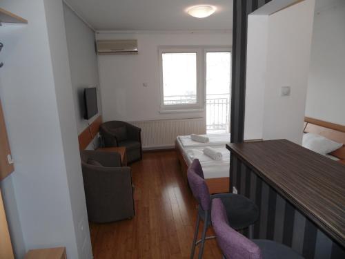 a living room with a room with a bed and chairs at Apartment Atina in Subotica