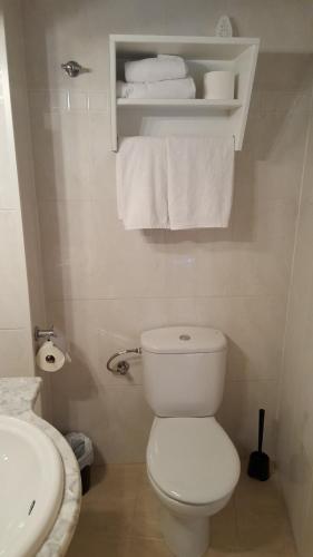 a bathroom with a toilet and a sink and towels at Enginyapartaments in Figueres