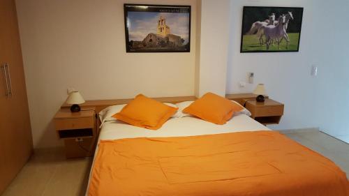 a bedroom with a bed with two orange pillows at Enginyapartaments in Figueres