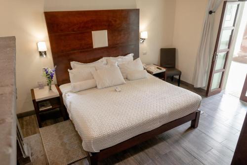 a bedroom with a large bed with a wooden headboard at Hotel La Morada in San Miguel de Allende