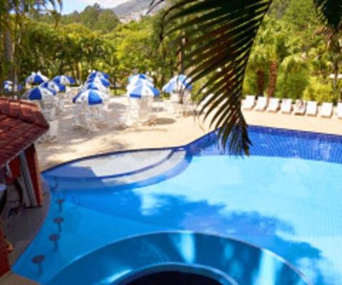 a blue swimming pool with blue umbrellas and a palm tree at Hotel Amoreiras in Extrema