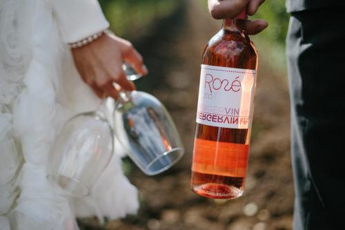 a person holding a bottle of wine at Berger Pince és vendégház in Császártöltés