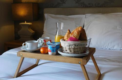 ニースにあるホテル ドゥ ラ メールのベッドの上に食べ物のバスケット入りのトレイ