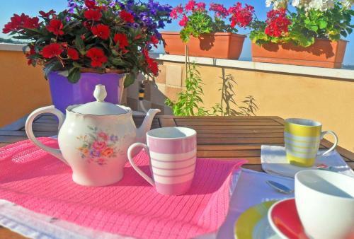 Ein Tisch mit zwei Tassen und einem Blumentopf in der Unterkunft B&B Le Terrazze Fermo in Fermo