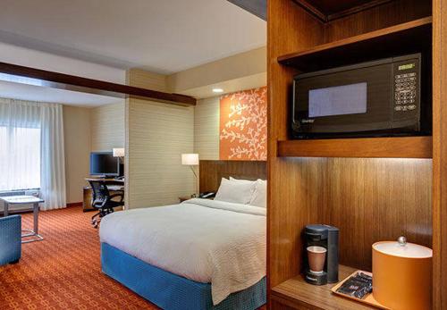 a hotel room with a bed and a television at Fairfield Inn & Suites by Marriott Detroit Canton in Canton