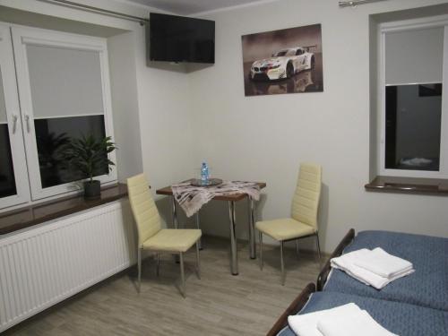 a room with a table and chairs and a bed at Heveliusz in Sokołów Podlaski
