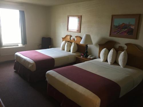 a hotel room with two beds and a window at Territorial Inn Guthrie Oklahoma in Guthrie
