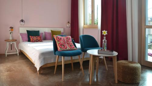 カロルツィオコルテにあるPicobello Zimmer & Atelierのベッドルーム1室(ベッド1台、椅子2脚、テーブル付)
