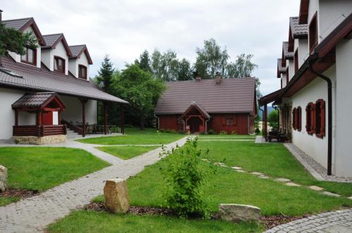 a courtyard of a building with a house at Jasminowe Wzgorze in Wilkanów