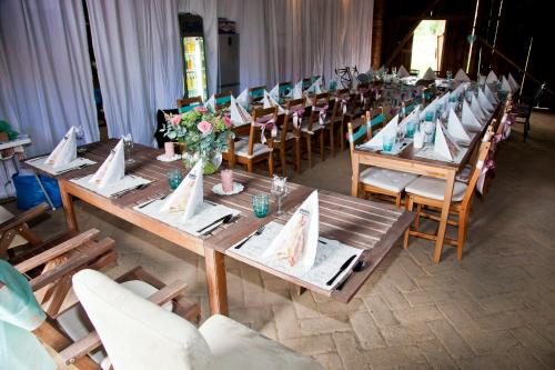 a row of wooden tables and chairs with flowers on them at Chateau Nightingales in Hostouň