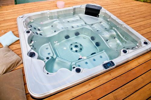 a hot tub sitting on top of a wooden table at Chateau Nightingales in Hostouň