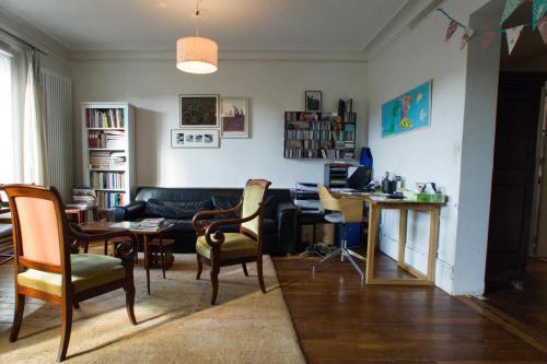 a living room with a couch and a table and chairs at Chambre d'hôte parisienne in Paris