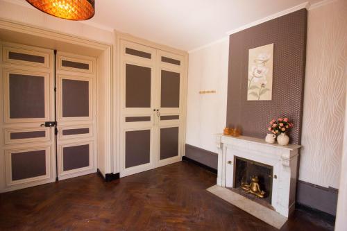 a living room with a fireplace and white doors at Domaine des Lilas in Saint-Germain-Lembron