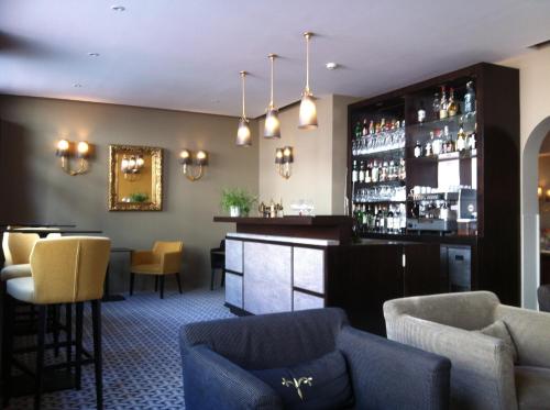 un bar dans un hôtel avec des chaises et un comptoir dans l'établissement Hôtel Le Cobh, à Ploërmel