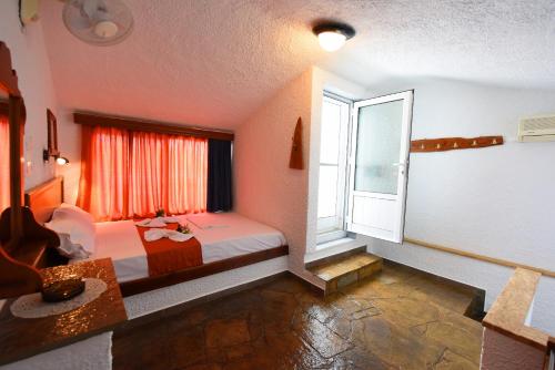 a bedroom with a bed and a large window at Haus Niko Apartments and Suites in Nea Potidaea