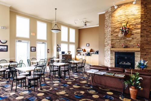 a lobby with tables and chairs and a fireplace at Canadian Motel North Battleford in North Battleford