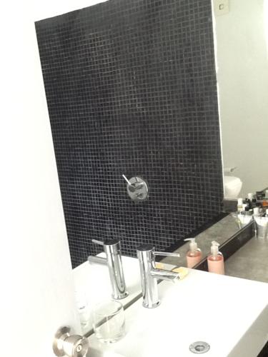 a bathroom with a mirror and a sink and a mirror at Las Glicinas Boutique Apartments in Colonia del Sacramento