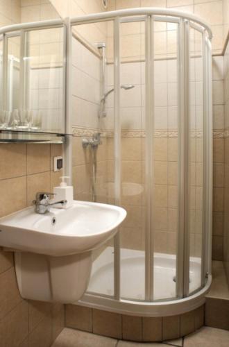 a bathroom with a sink and a shower at Pensjonat Mijamar in Białogóra